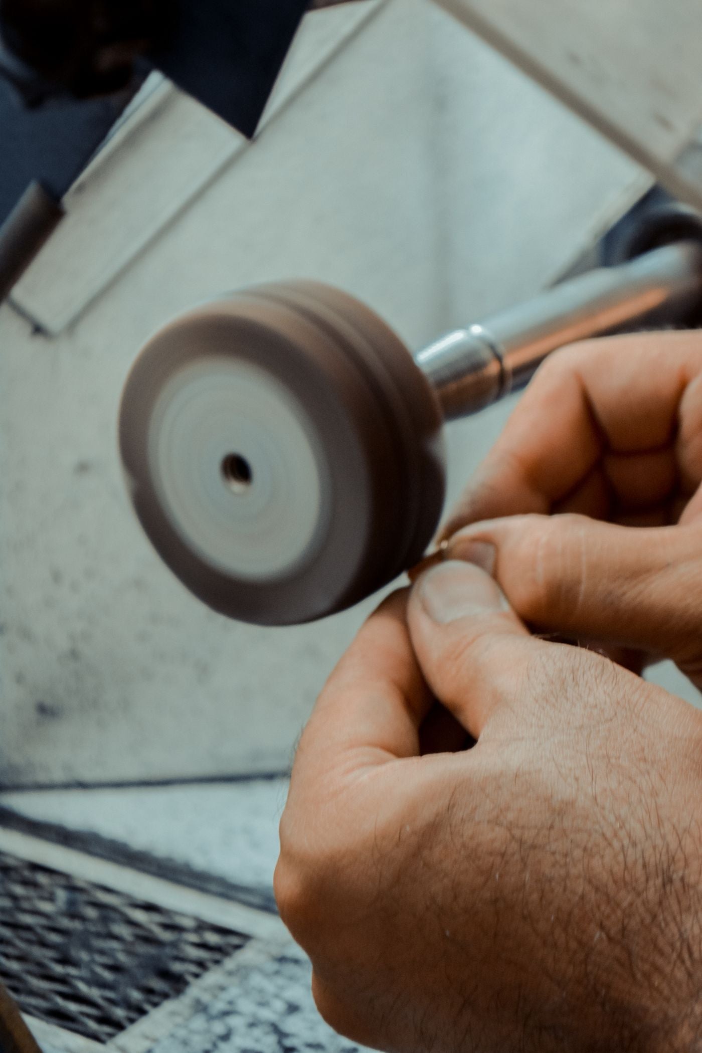 Technician finishing a metal component in a workshop